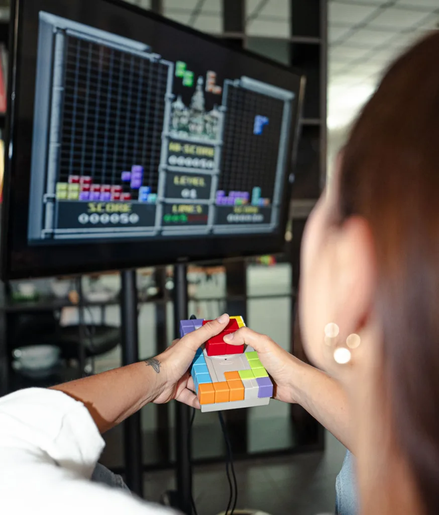 Mani su un controller davanti a uno schermo con un videogioco